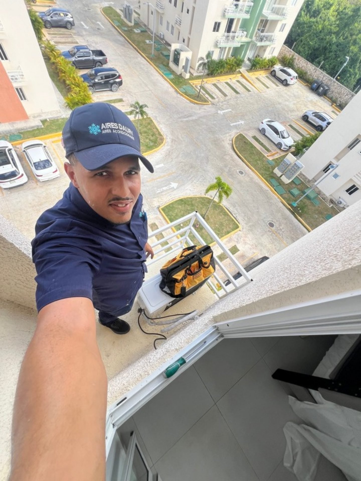 Técnico de Aires Daury instalando un aire acondicionado en un balcón de Punta Cana